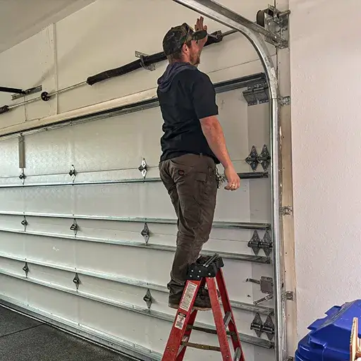 Garage door adjustment by handyman during custom storage setup